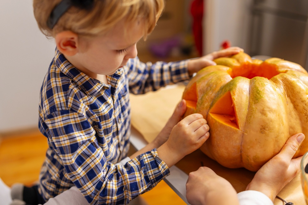 A child carving a pumpkin.