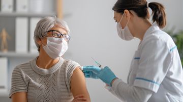 Doctor giving a senior woman a vaccination. Virus protection.