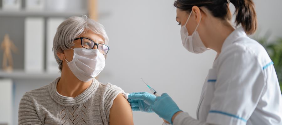 Doctor giving a senior woman a vaccination. Virus protection.